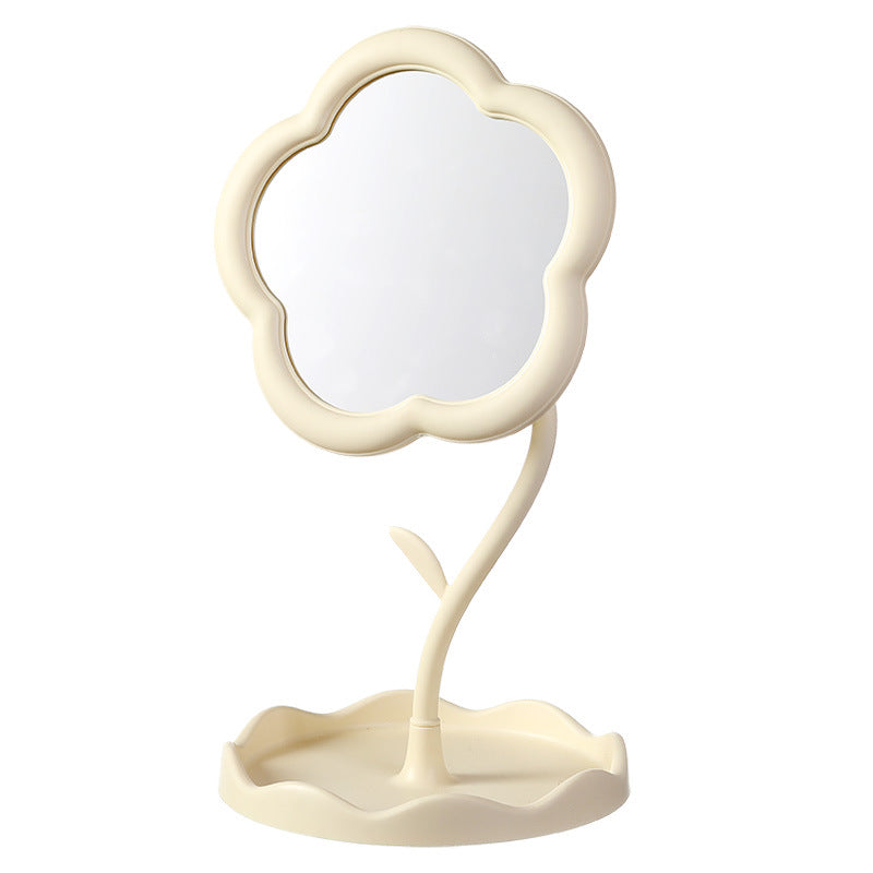 Freestanding white flower-shaped tabletop mirror with its base on a pale background