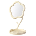 Freestanding white flower-shaped tabletop mirror with its base on a pale background